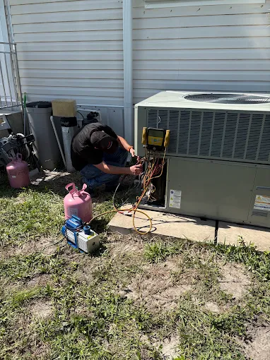 Technician checking a residential packaged AC system with refrigerant gauges