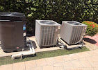 Two outdoor AC condensers beside pool equipment