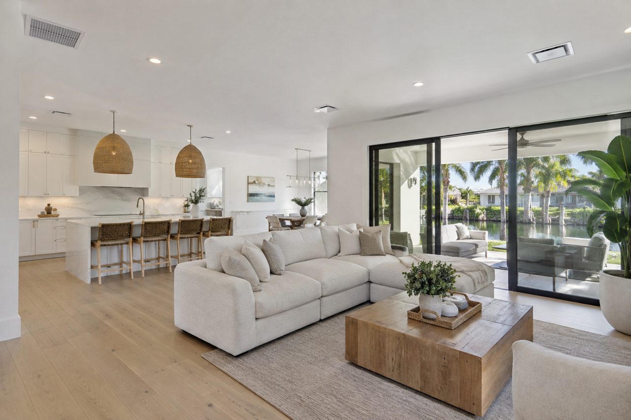 Bright open-plan living room of a modern Delray Beach home with white oak floors, linen sofa, ceiling return air grille and clean supply diffusers, airy daylight